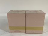 two boxes of perfume sitting on top of a white surface
