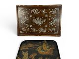 two trays with decorative designs on them sitting next to each other