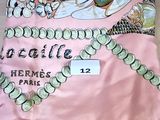 une écharpe rose sur laquelle est représenté le collier d'une femme