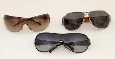 three pairs of sunglasses are shown on a white surface