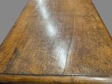 a wooden table with a metal base on a gray background