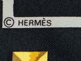 a close up of a tie with a yellow square on it