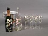 plusieurs verres et une bouteille de vin à côté d'un seau