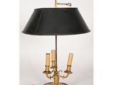 une lampe de table en laiton surmontée d'un abat-jour noir