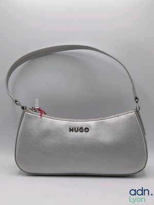 the purse is silver and has a red bow on the handle