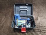 une trousse à outils dans un coffret en plastique posé sur le sol