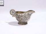 une saucière en argent ornée d'un motif floral sur le côté