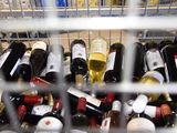 many bottles of wine sitting in a metal basket