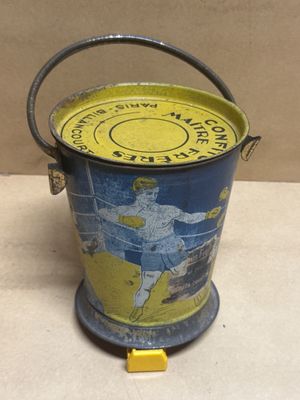 un seau jaune et bleu sur lequel est représenté un joueur de tennis