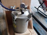 a metal pot sitting on a pallet with a hose attached to it