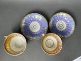 two cups and a saucer sitting on a table next to a ruler