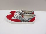 red and white sneakers with black letters on them on a white surface