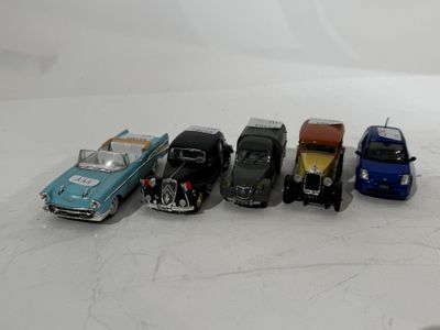 several toy cars are lined up in a row on a white surface
