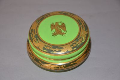 a green and gold box with a picture of a bird on it