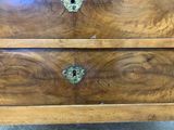 a wooden chest of drawers that has a lock on it