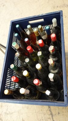 many bottles of wine in a blue crate on the floor
