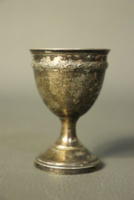 une coupe en argent posée sur une table, sur fond blanc