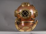 un casque de plongée ancien posé sur une surface blanche