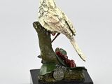 statue of a bird on a branch with berries on a white background