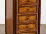 une commode ancienne en bois montée sur roulettes, posée sur un sol carrelé