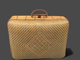a brown and tan suitcase with a handle on a gray background