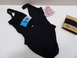 a black bodysuit on a white table next to a brown bag