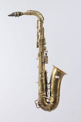 an old brass saxophone on a stand against a white background