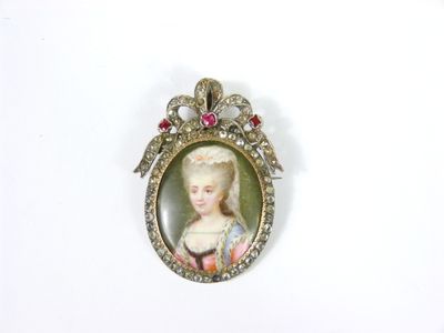 une petite image représentant une femme en robe, fixée sur une broche