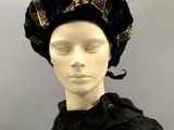 a close up of a mannequin wearing a black dress and a blue hat
