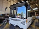 a large white bus parked in a garage