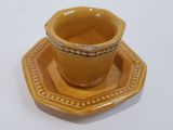 a small yellow cup and saucer on a saucer