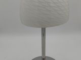 un gros plan d'une lampe de table posée sur une surface blanche