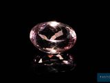 a close up of a pink diamond on a black surface