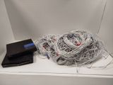 a pile of wires on a shelf next to a cd player