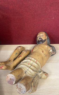 a statue of jesus laying on a wooden table