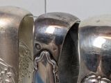 three silver spoons sitting on a table next to each other