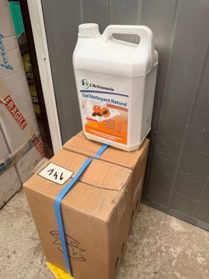 un récipient contenant un liquide posé sur une boîte en carton