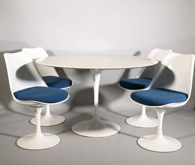 three chairs and a table in a white room