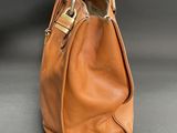an image of a brown leather handbag on a gray surface