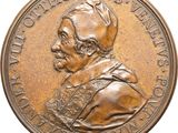 a close up of a bronze medal with a man ' s face on it