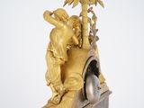 a gold clock with a statue on top of it