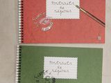 three notebooks with writing on them sitting on a table