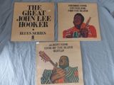 three posters of the great john lee hooker blues series on a bed