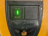a close up of a yellow parking meter with a green light