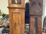 a grandfather clock sitting next to a tall wooden grandfather clock
