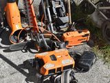 several chainsaws and other tools sitting on the ground next to a trash can