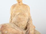 a statue of a man sitting on top of a rock