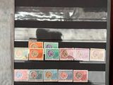 une personne tenant un livre sur lequel sont collés plusieurs timbres
