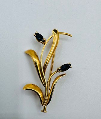 une broche en or ornée de pierres noires