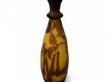 un vase marron orné d'un oiseau sur un fond blanc